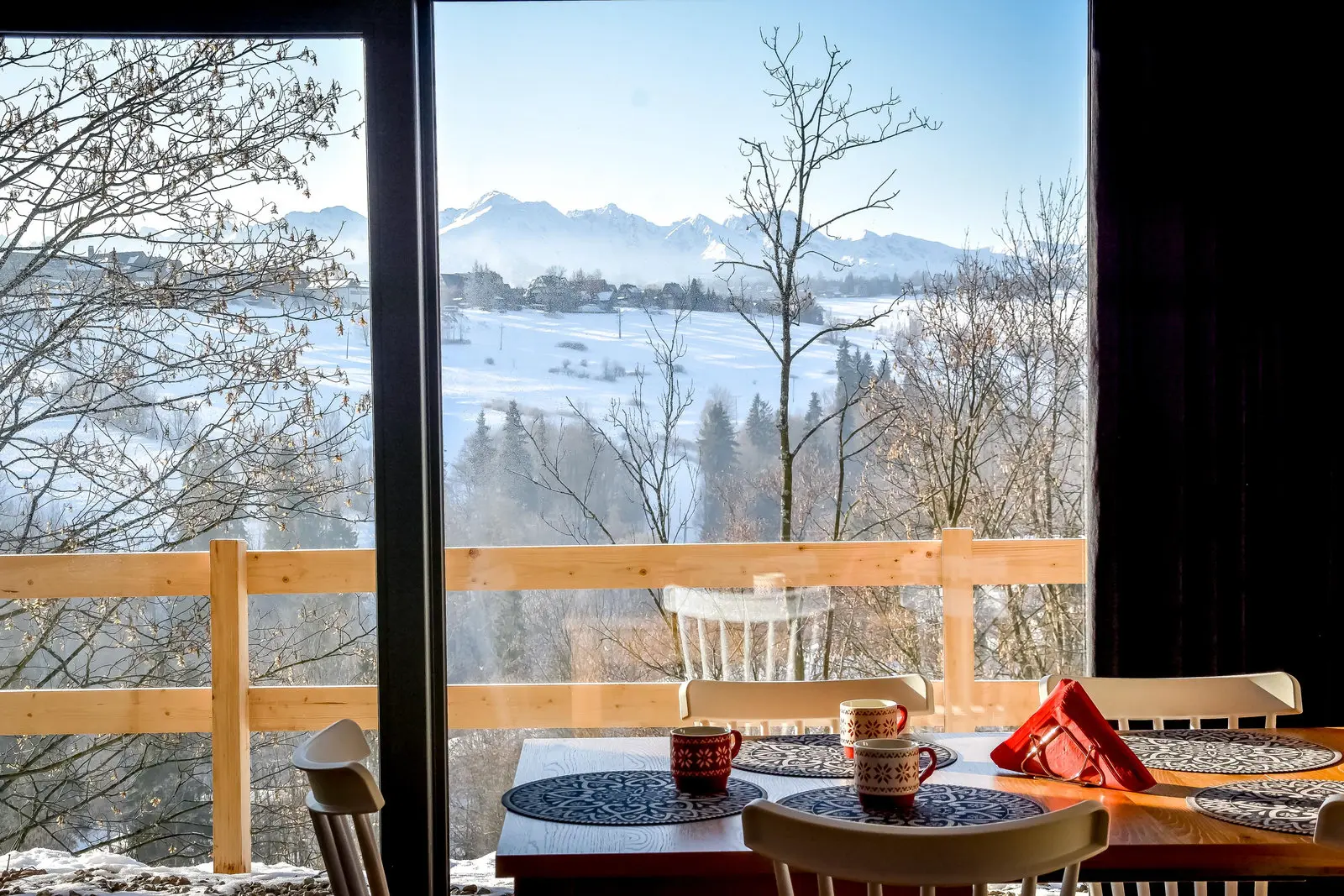 Widok na Tatry przez okno jadalni z czerwonym góralskim kubkiem — Domki Rusiński Raj, Bukowina Tatrzańska